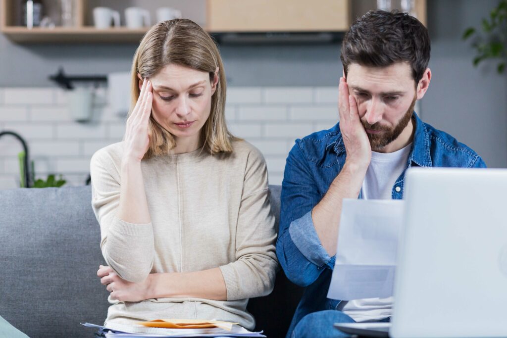 Hombre y mujer mirando el portátil con frustración.
